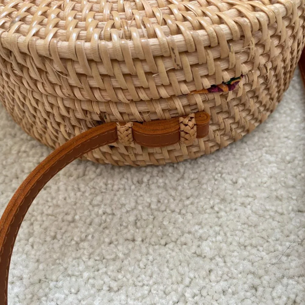 Round solid rattan woven crossbody purse cloth lined, leather accents.
